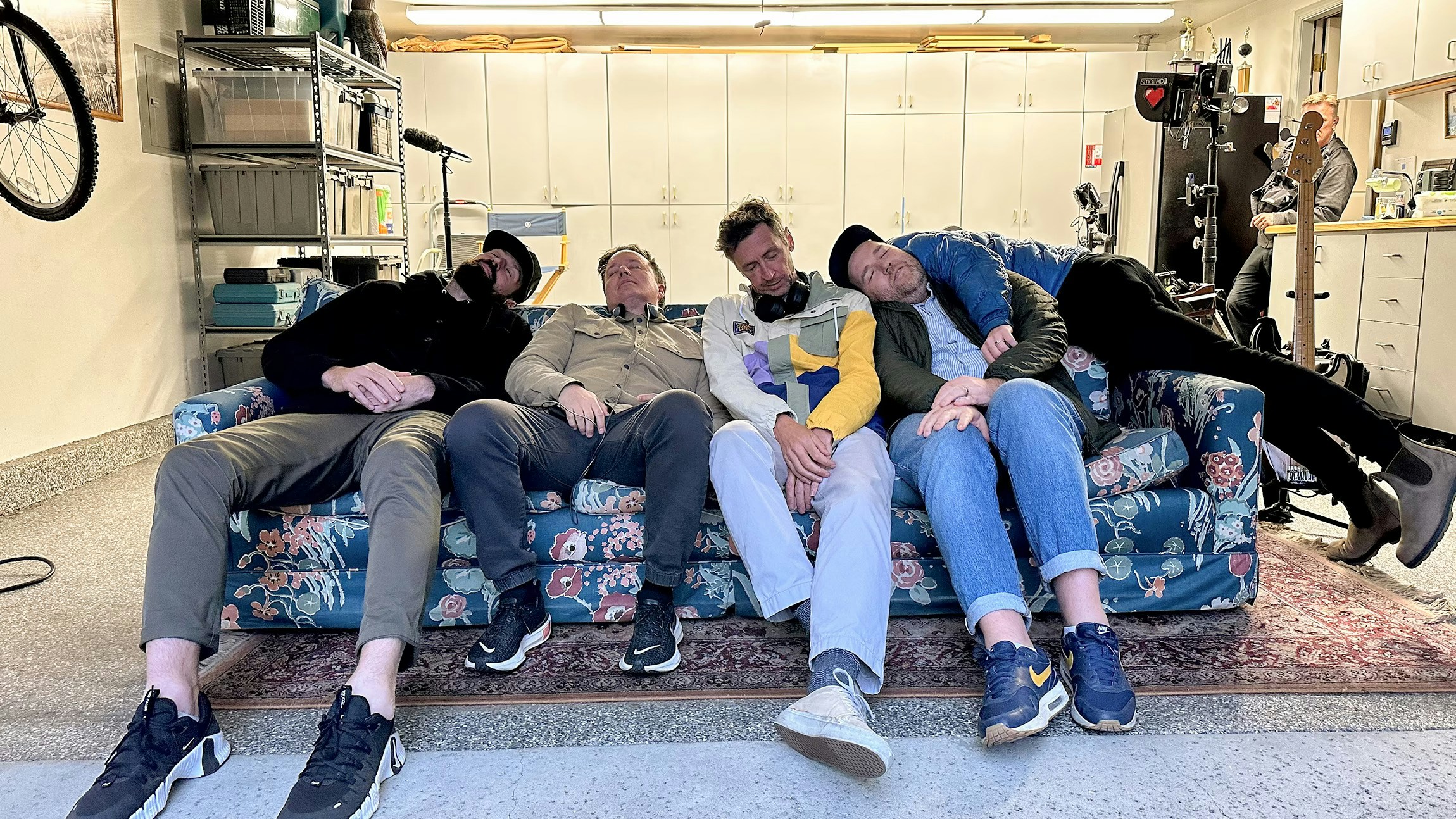 Team lounging together on a floral couch in a garage space.