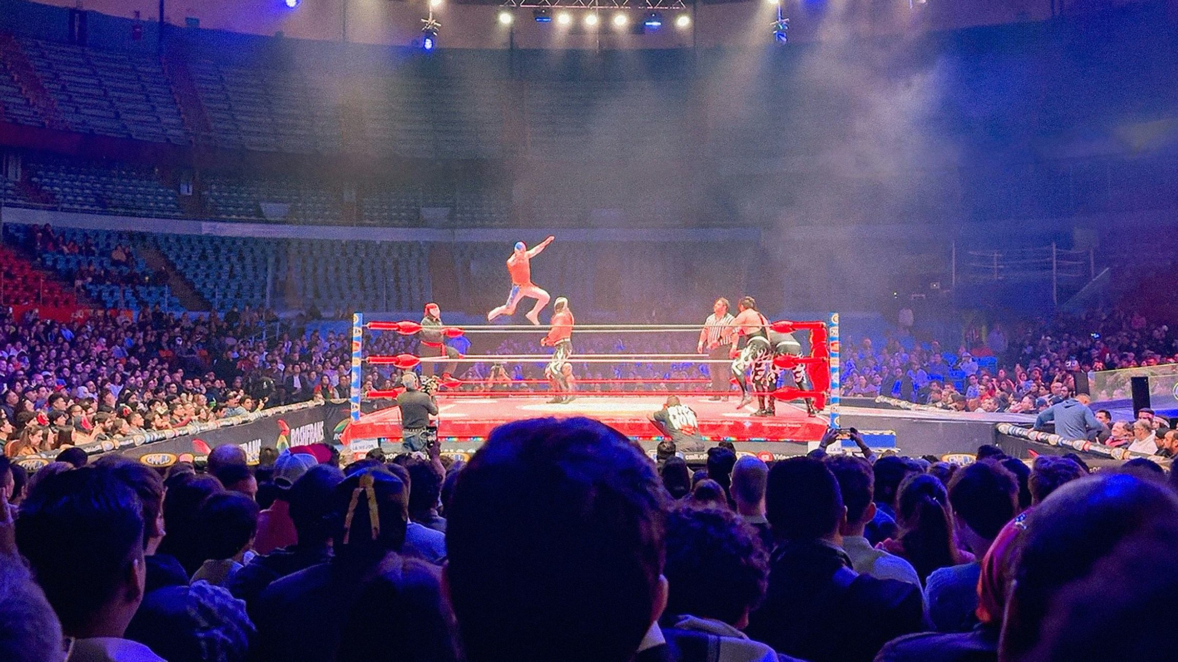 Crowd watches colorful lucha libre wrestling match in Mexico City arena