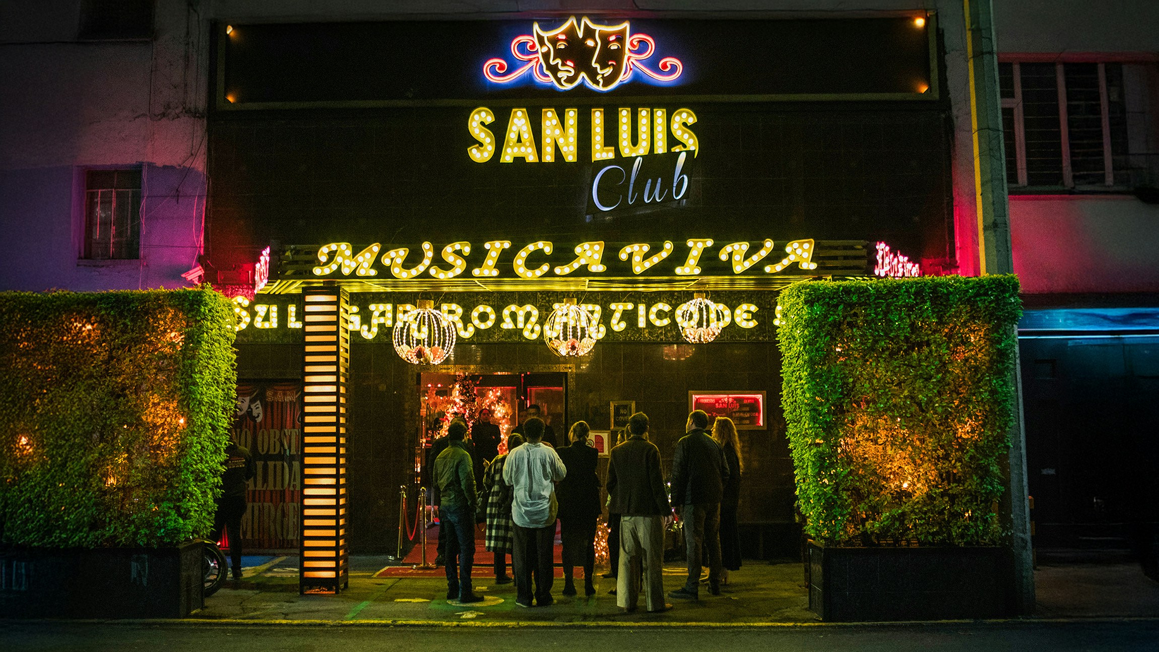 Neon-lit exterior of San Luis Club in Mexico City at night
