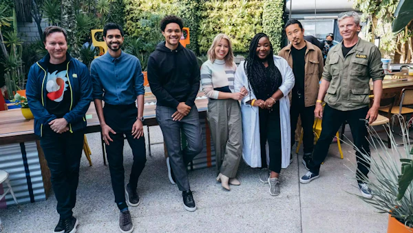 Trevor Noah and Alto team standing in front of an Expensify sign